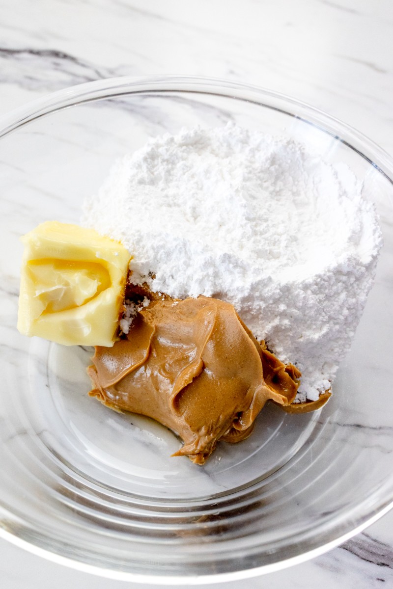 Powdered Sugar, Peanut Butter and Butter in a mixing bowl