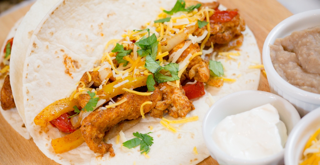 Close up of an open chicken fajita wrap.