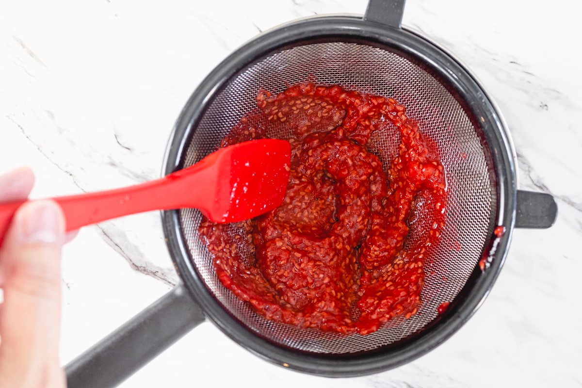 Pressing Raspberry Puree in mesh to remove seeds