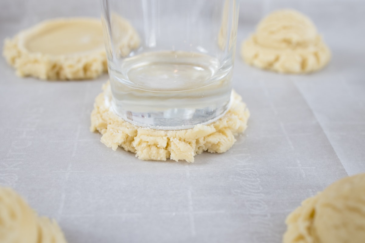 Press Sugar Cookies with a glass dusted in sugar