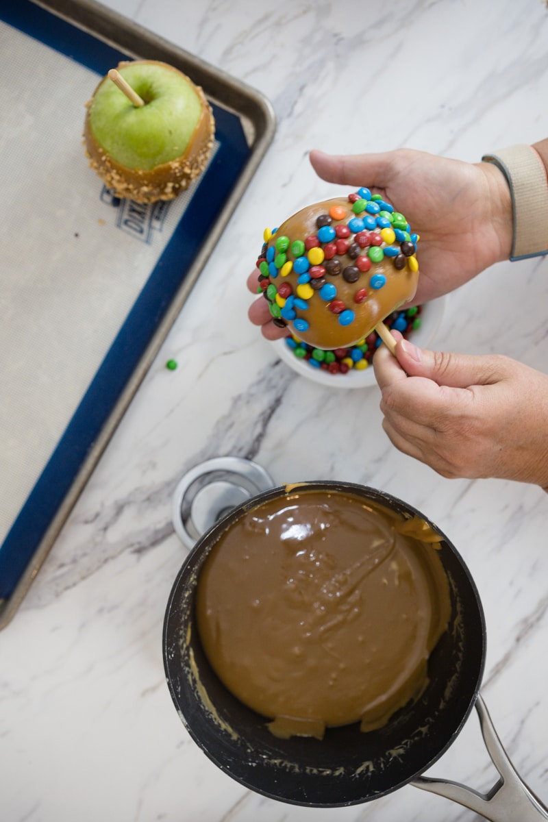 Add toppings to dipped apples