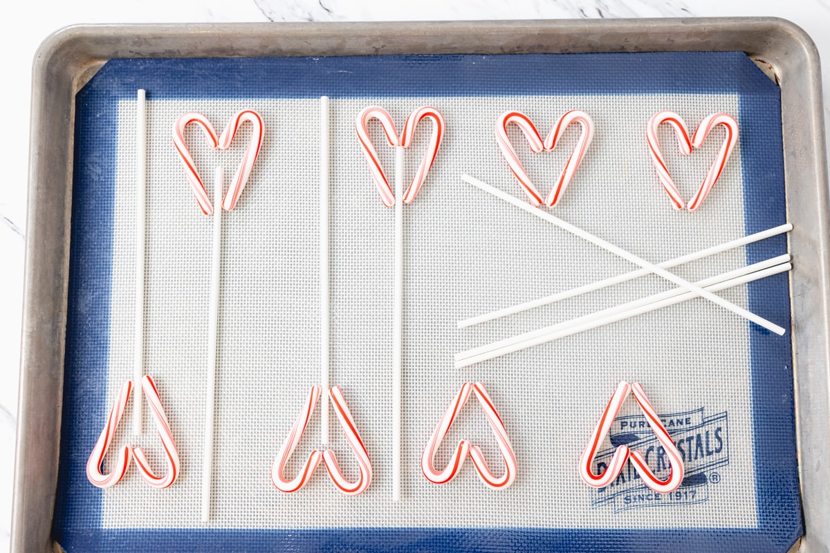 Place Candy Canes and sucker sticks on baking sheet