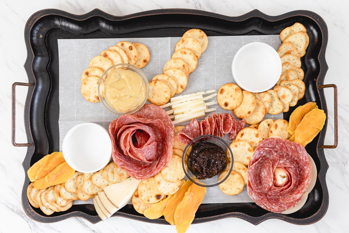 Adding Crackers and Meats to Charcuterie Board