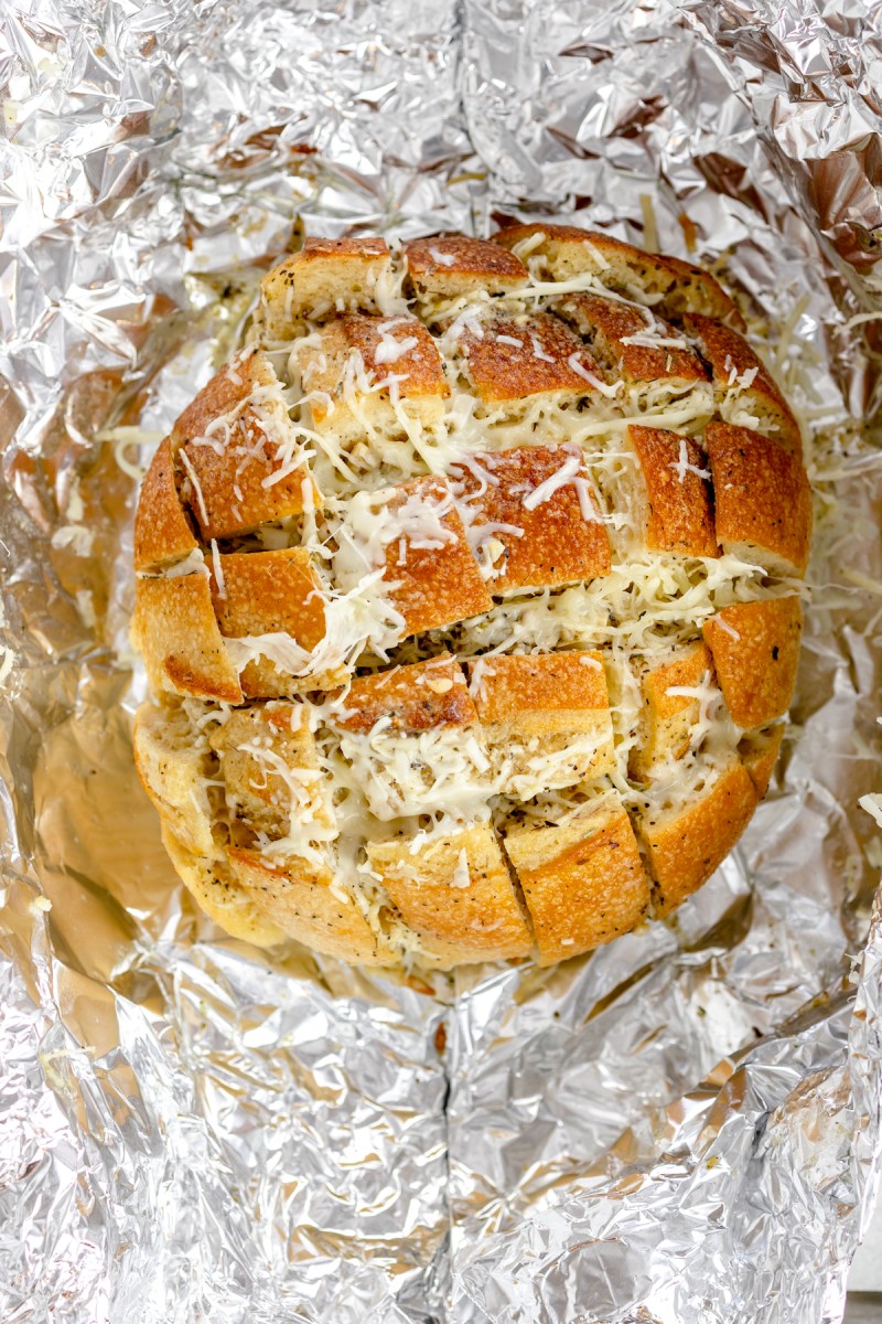 Top view of cheesy pull-apart loaf on top of tin foil. 