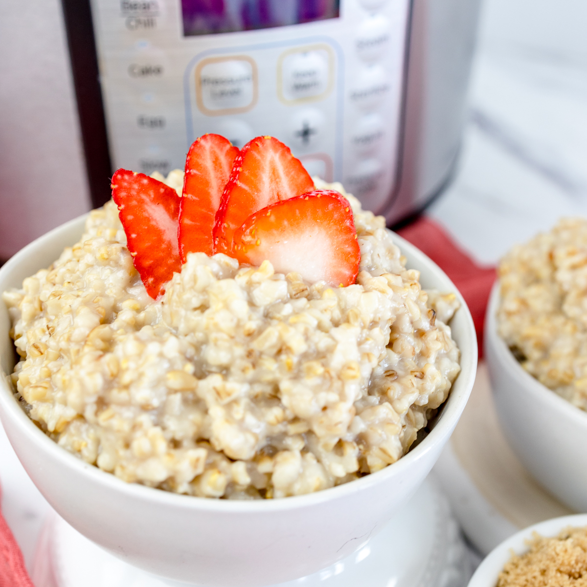 Close up of a bowl of Instant Pot Steel Cut Oats with sliced strawberries on top.
