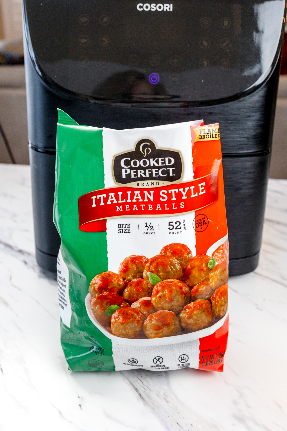 A bag of frozen meatballs on a counter in front of an air fryer.
