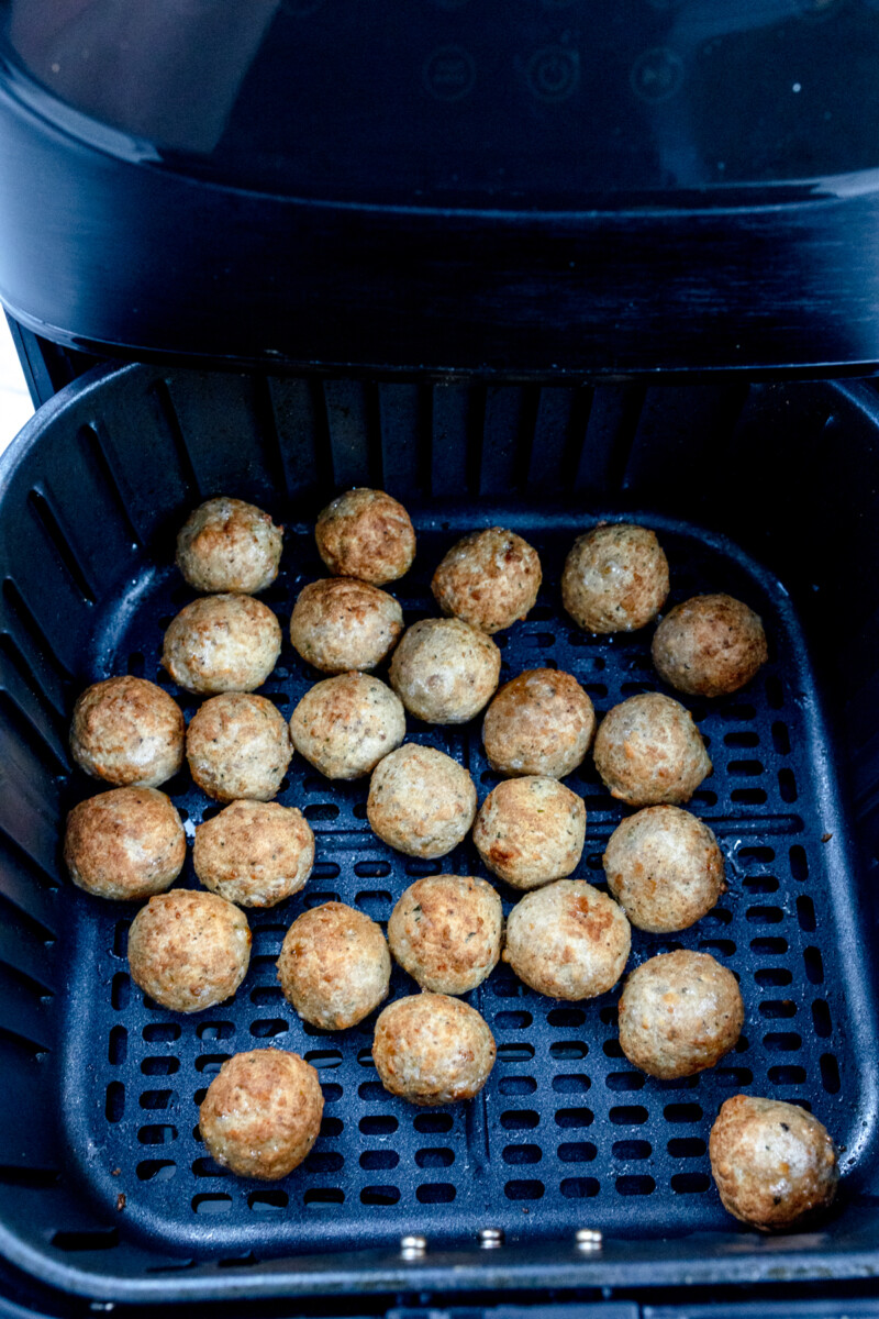 Top view of cooked meatballs in an air fryer.
