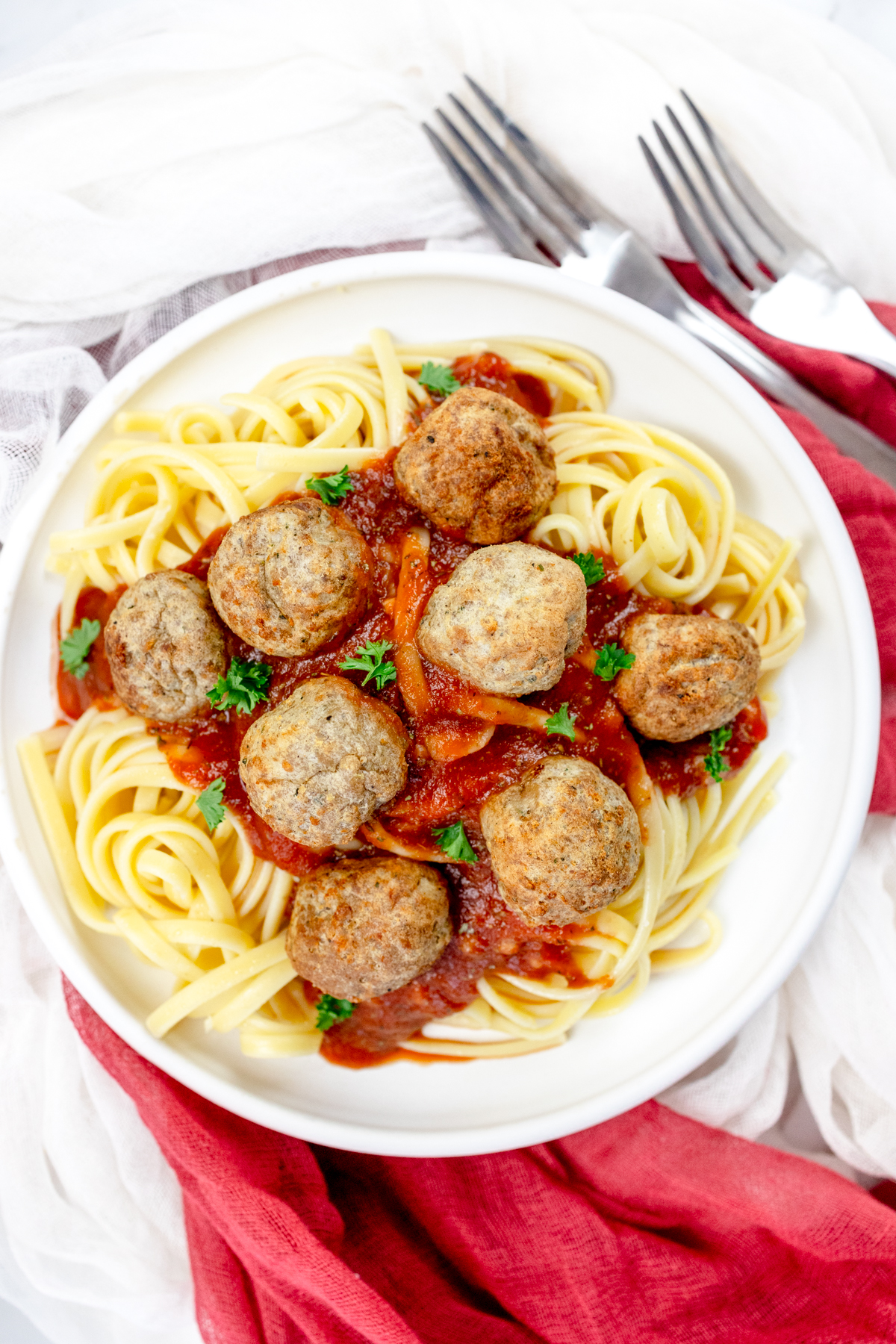 Close up view of a plate of spaghetti meatballs.