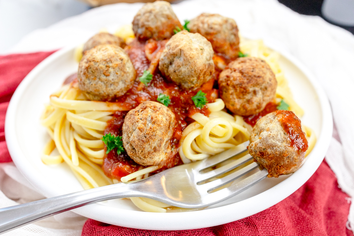 Close up view of a plate of spaghetti meatballs.