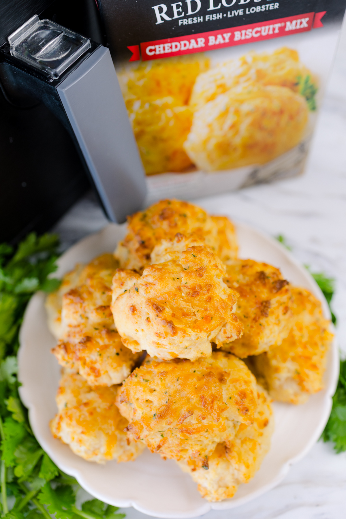Red Lobster Biscuits in a pile on a white plate next to an air fryer and a box mix.