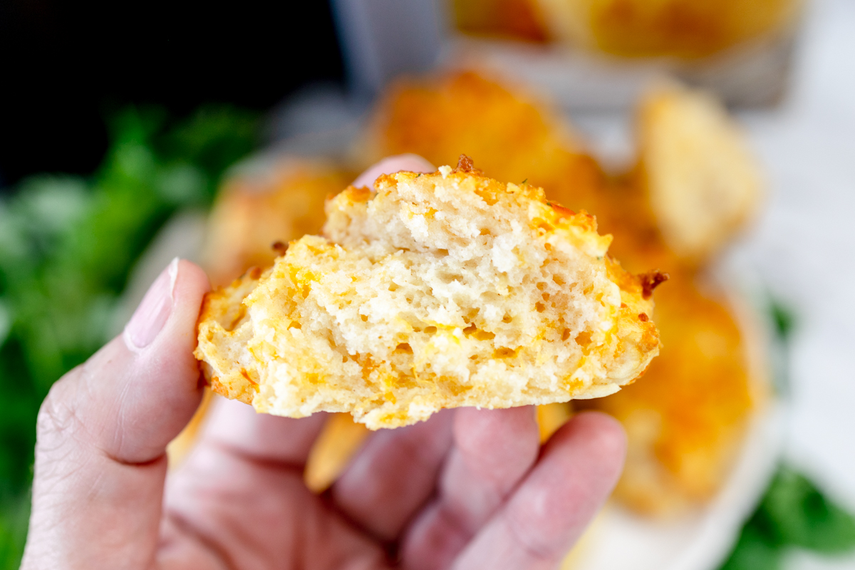 Close up of a Red Lobster Cheddar Bay BIscuit being held in mid-air.