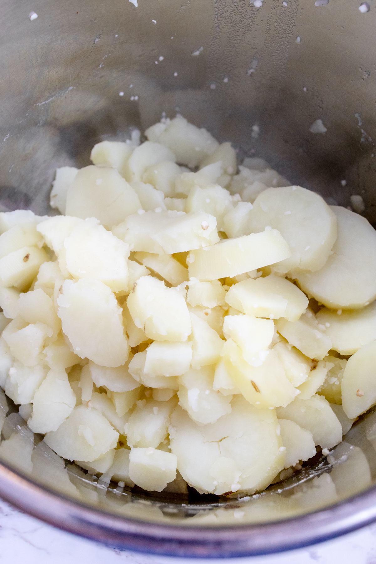 Close-up view of n Instant Pot liner with drained potatoes in it.