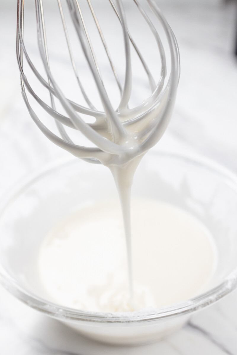 Close view of icing being whisked together.