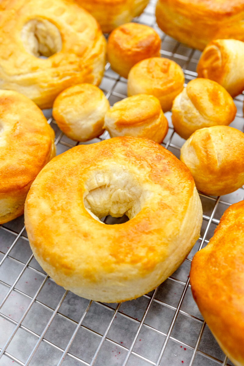 Close up view of freshly air fried biscuit donuts cooling on a wire rack before being glazed.