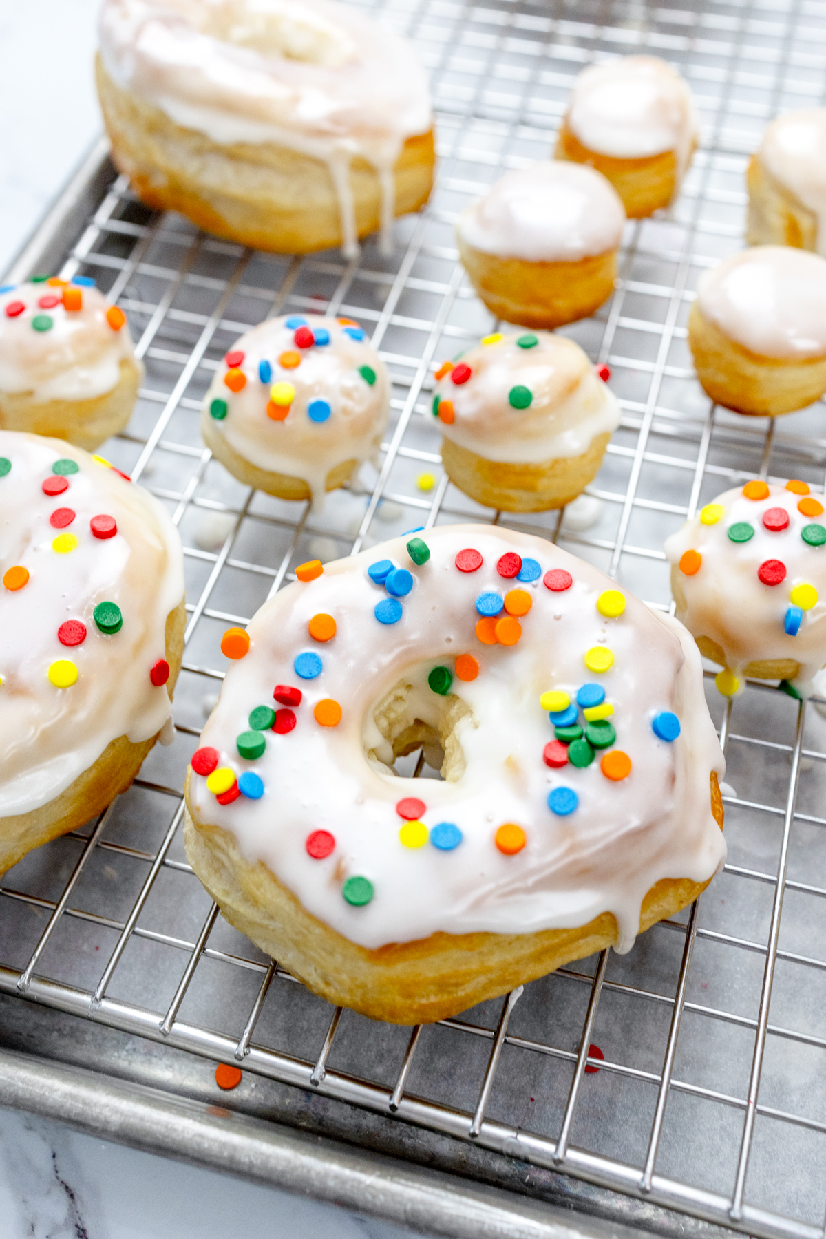 Close view of iced and decorated biscuit donuts and donut holes.