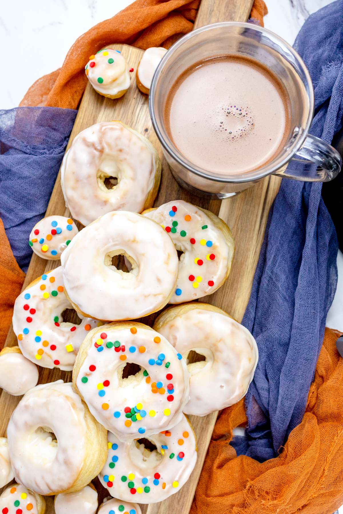 Close view of iced and decorated biscuit donuts and donut holes.