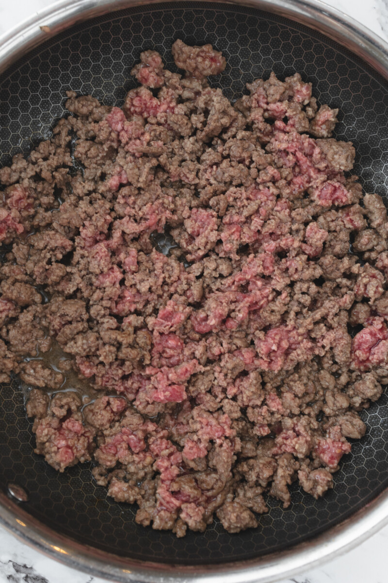 Top view of ground beef being browned in a pan.