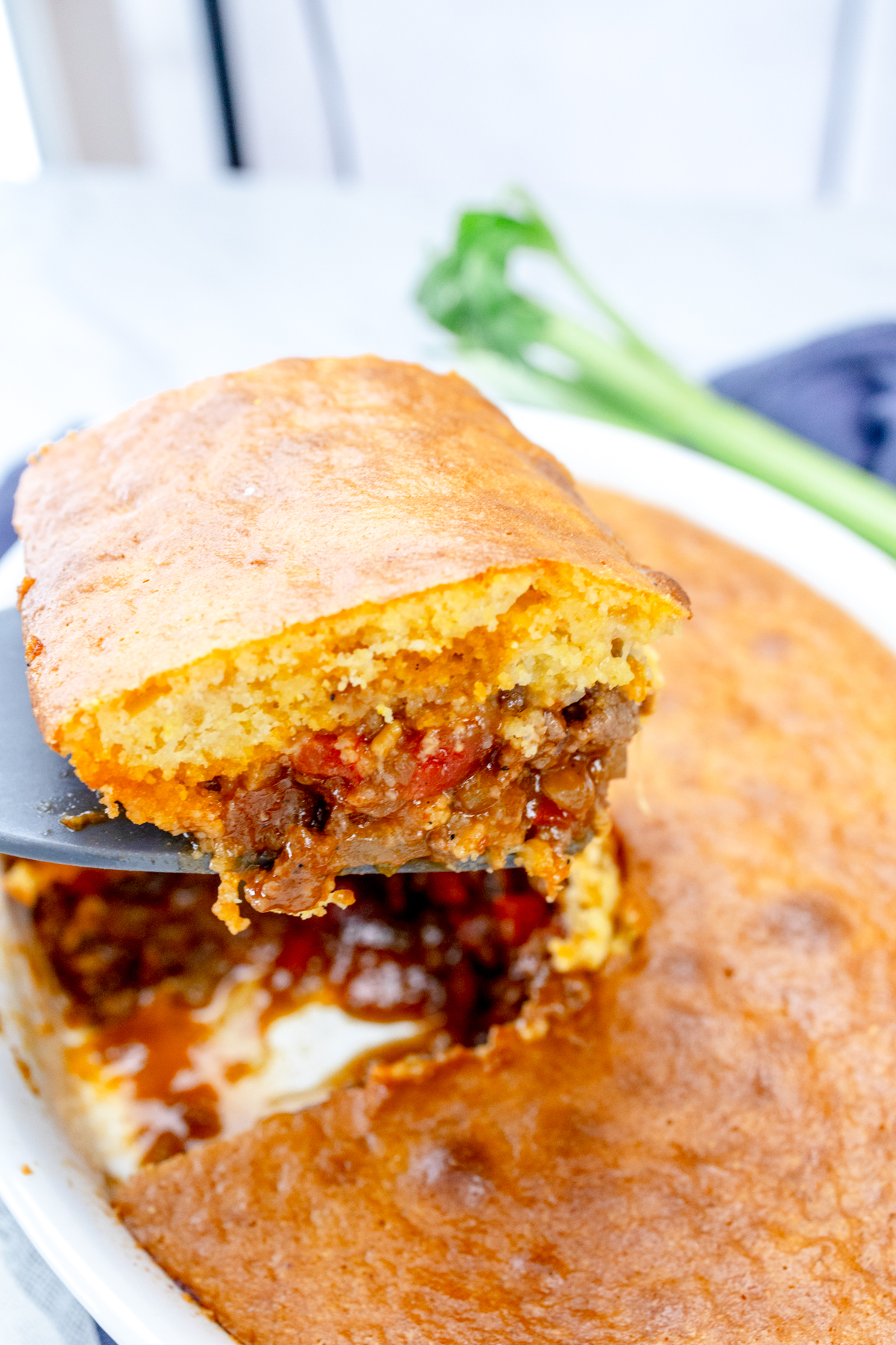 Close up of a spatula lifting a portion of sloppy joe casserole out of the dish.