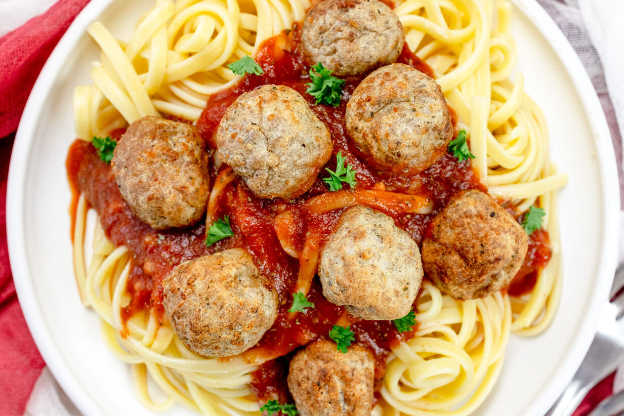 Close up view of a plate of spaghetti meatballs.