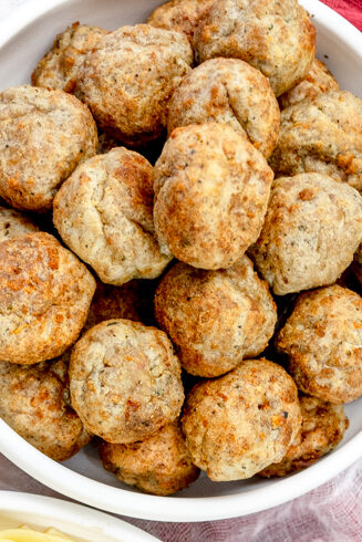Close up view of a plate of spaghetti meatballs next to a bowl of meatballs.