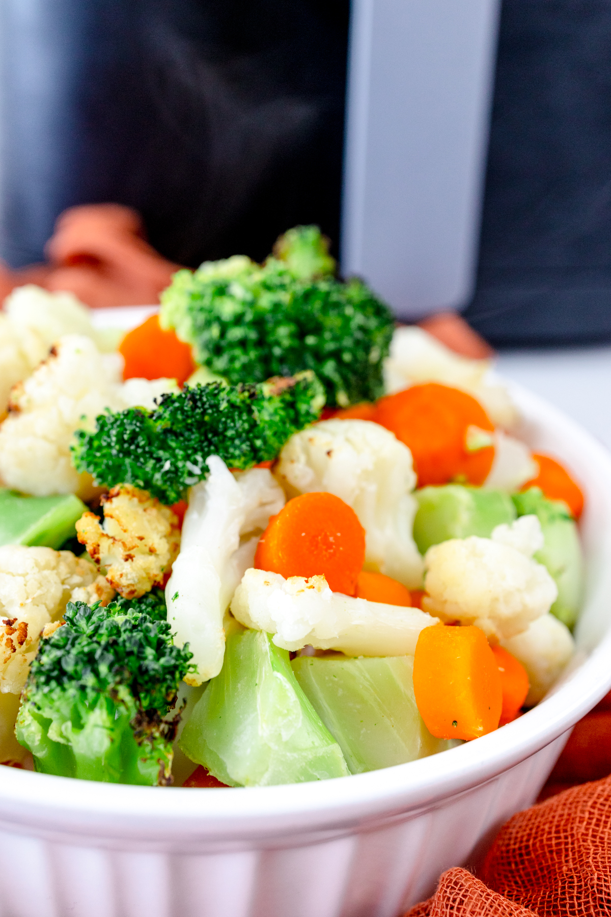 Close up view of a white bowl full of mixed vegetables.