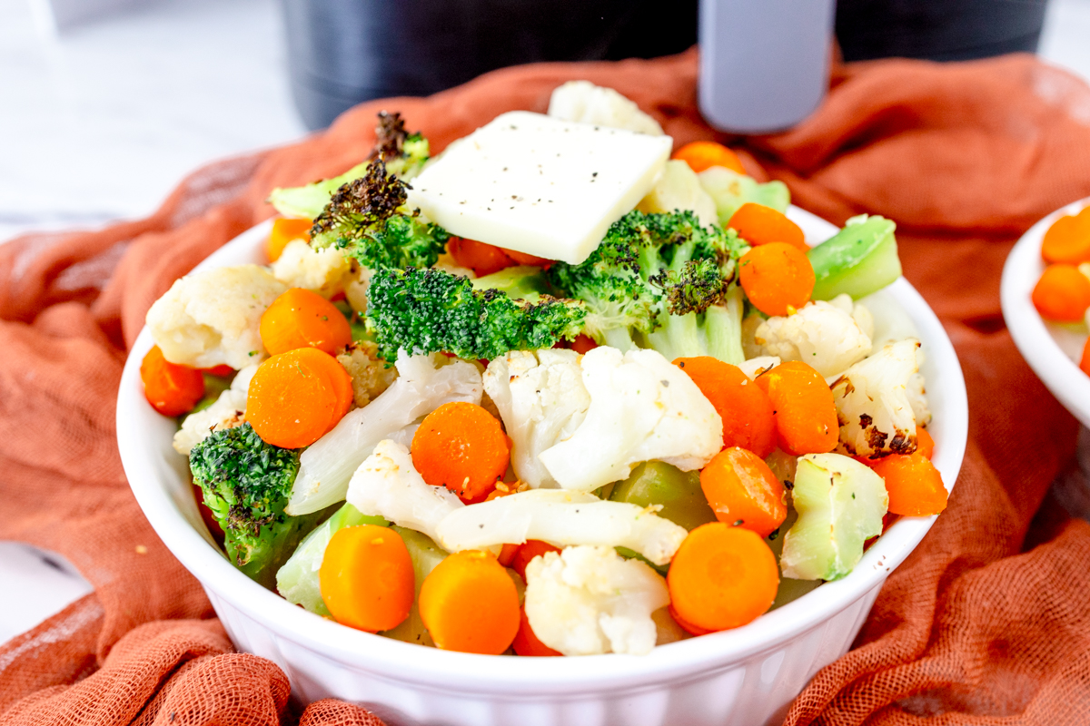 Close up view of a white bowl full of mixed vegetables.