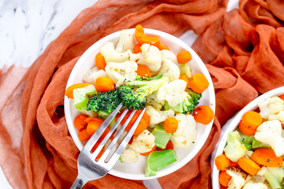 Top view of a white plate full of mixed vegetables.