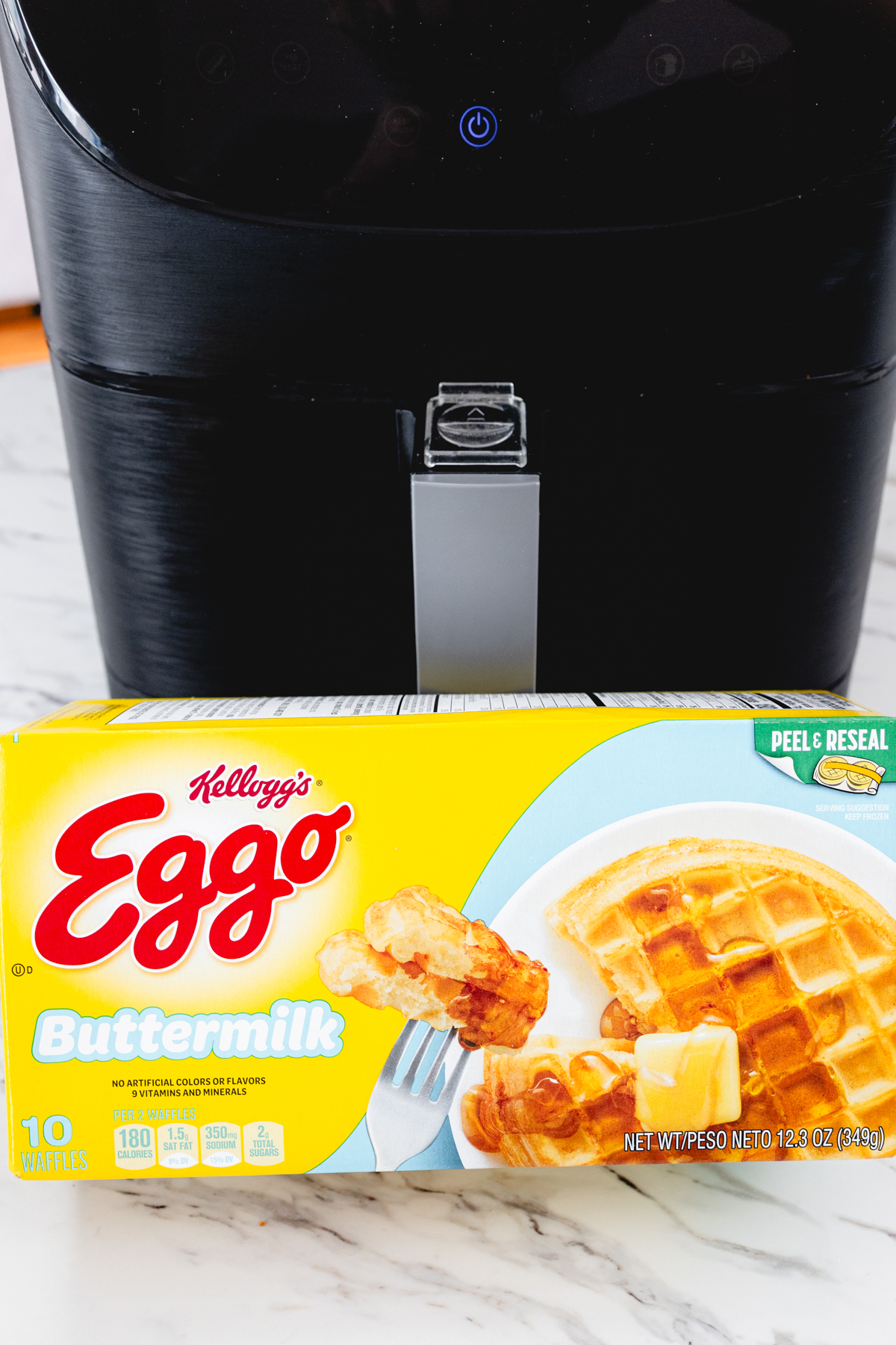 Close view of a box of eggo waffles in front of an air fryer.