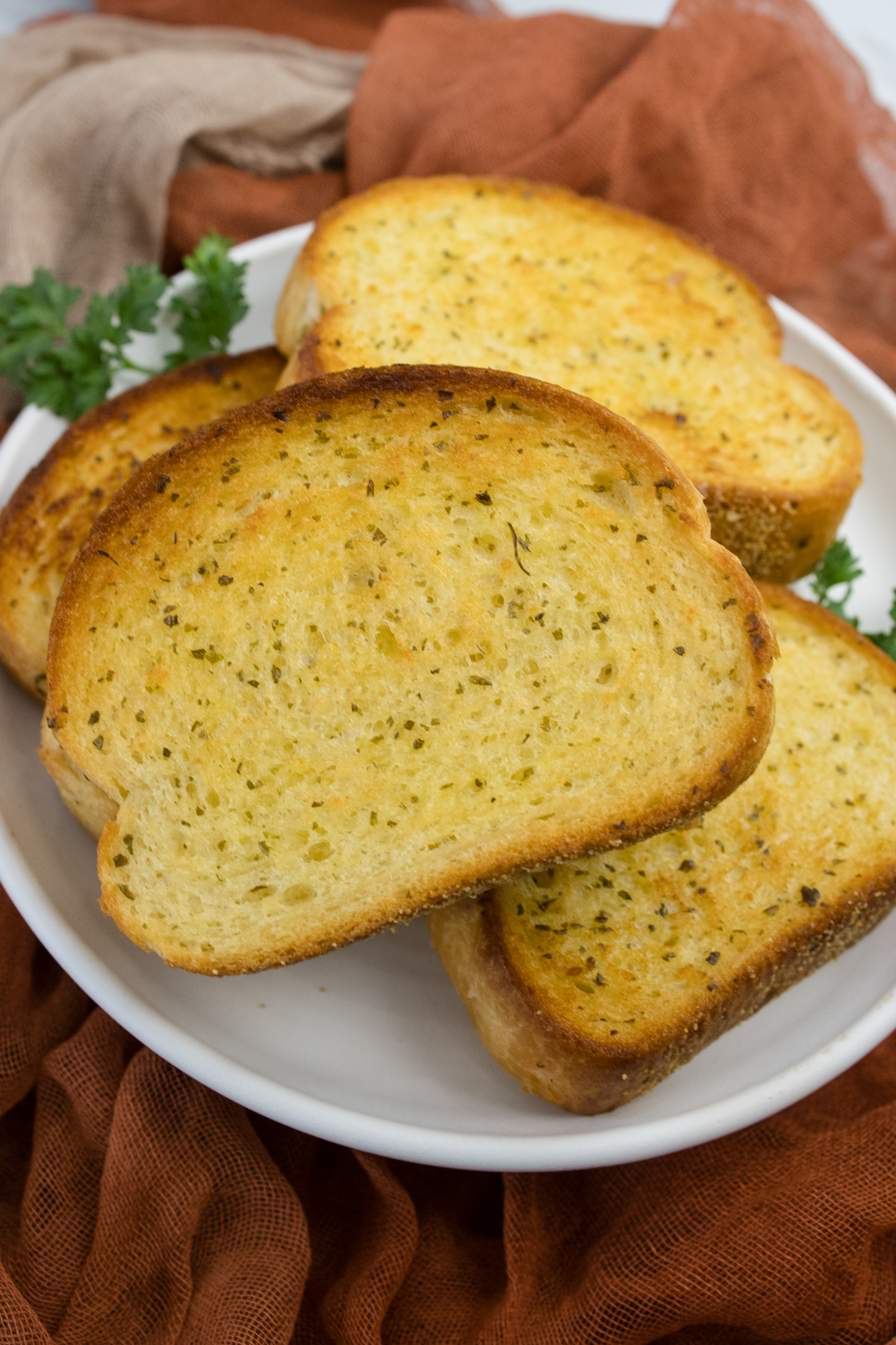 Close up view of Texas Toast stacked on a white plate.