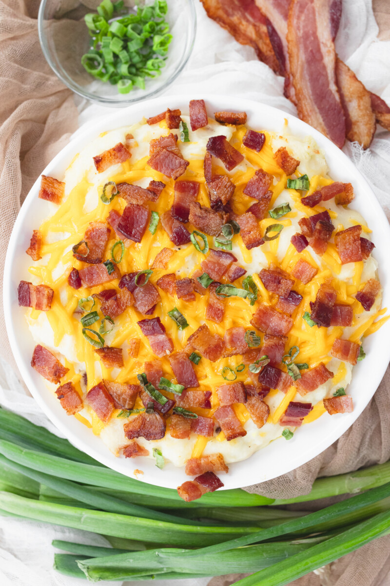 Top view of a white dish filled with loaded mashed potatoes.