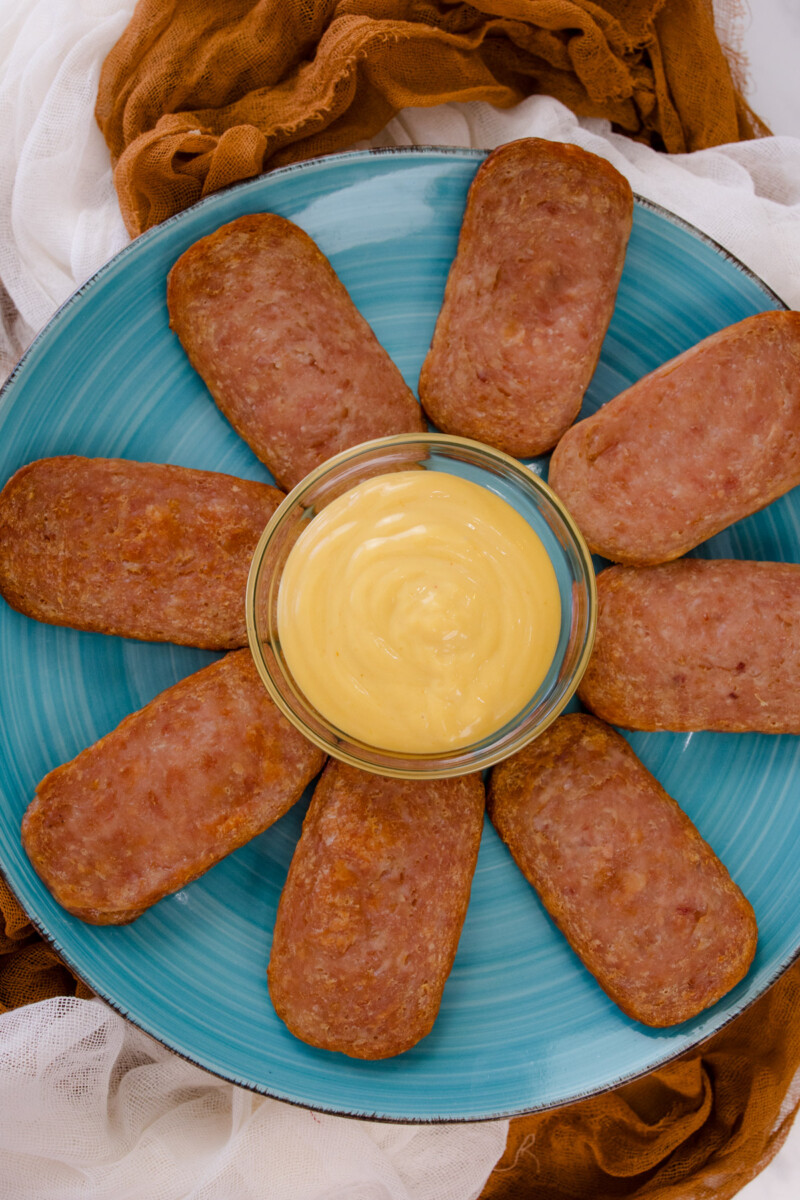 Air Fried Spam slices arranged on a blue plate in a starburst formation with a small bowl of dipping sauce in the center.