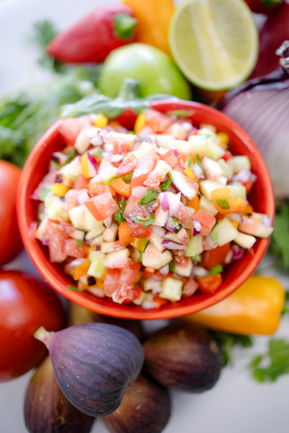 A bowl of Fig Salsa surrounded by fresh ingredients.