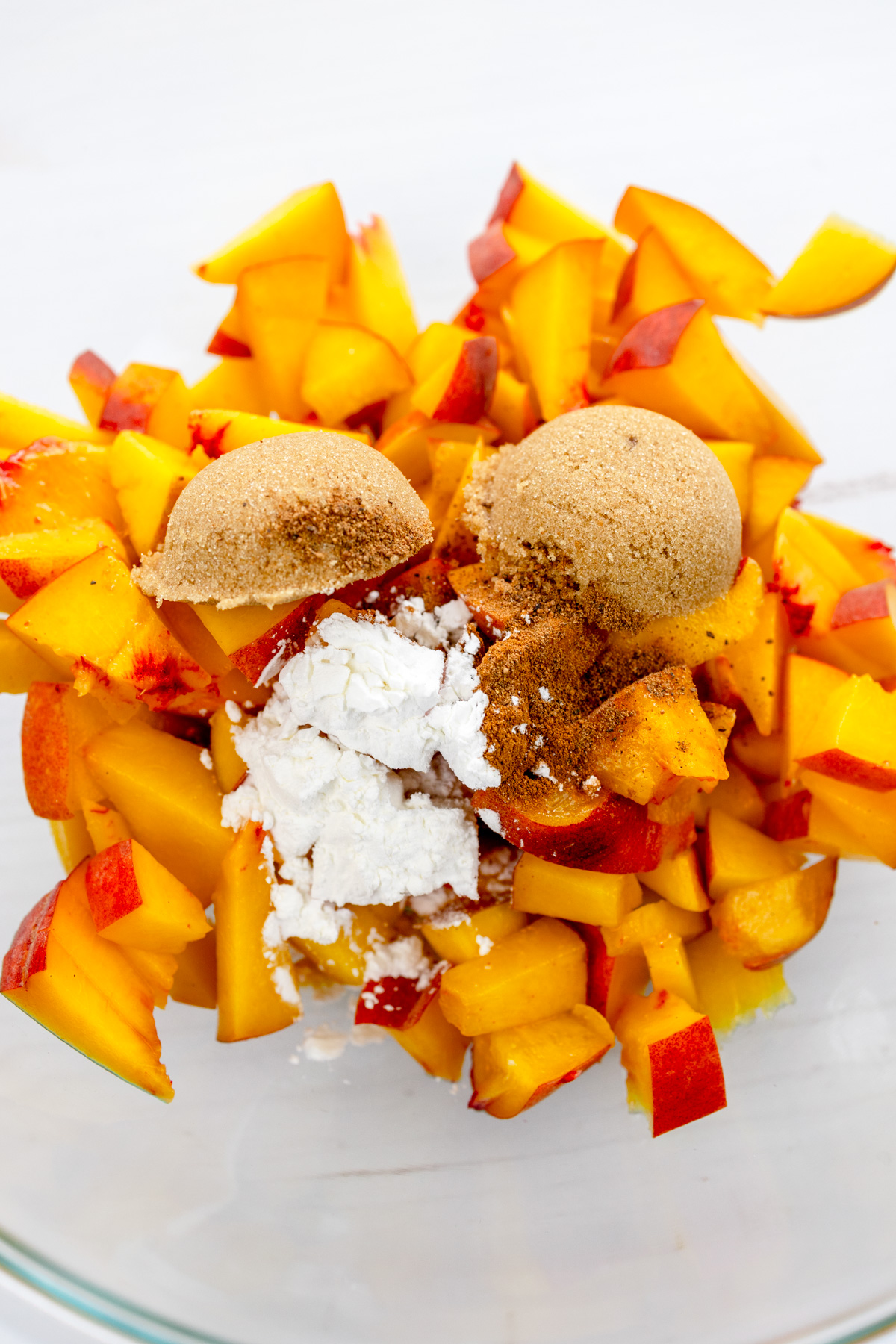 Overhead image of the ingredients needed to make the peach slices mixture in a mixing bowl.