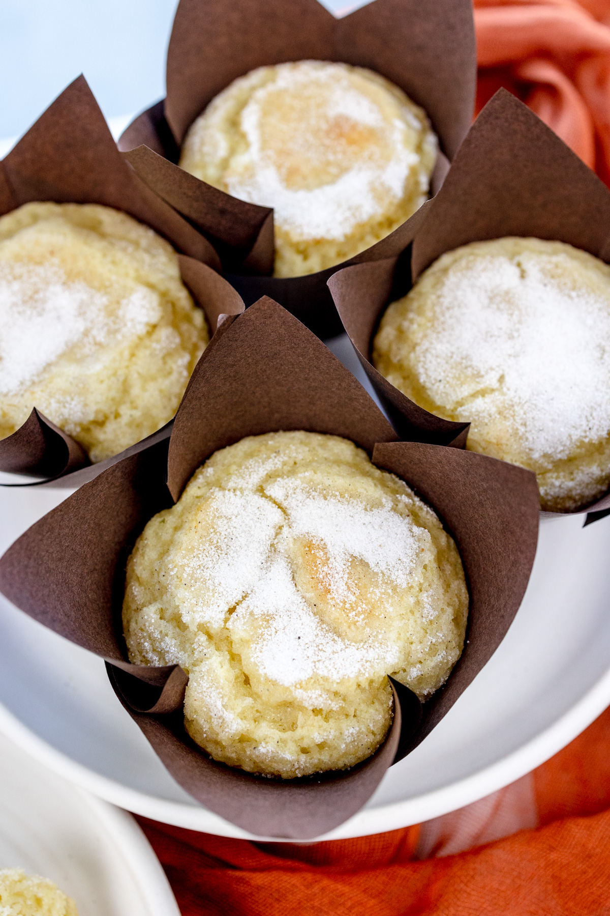 Close up overhead image of four cardamom muffins on a white plate.
