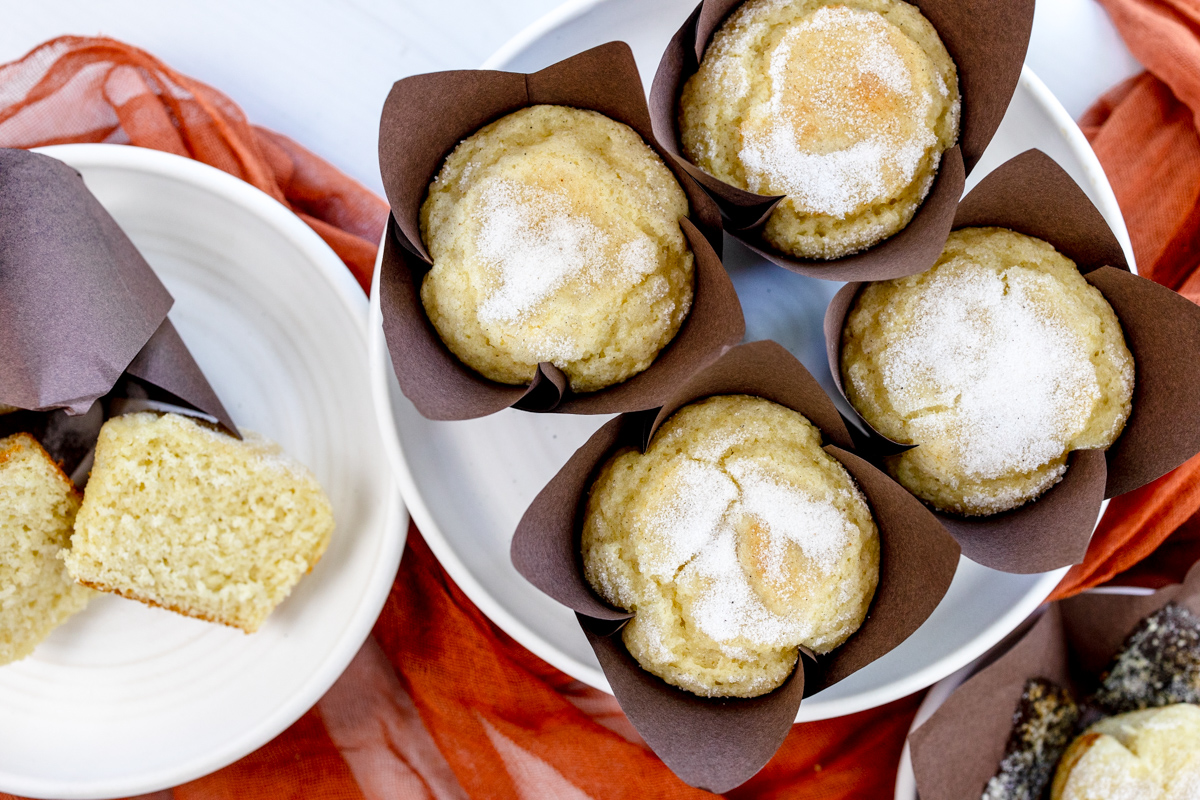 Overhead image of four cardamom muffins on a white plate.