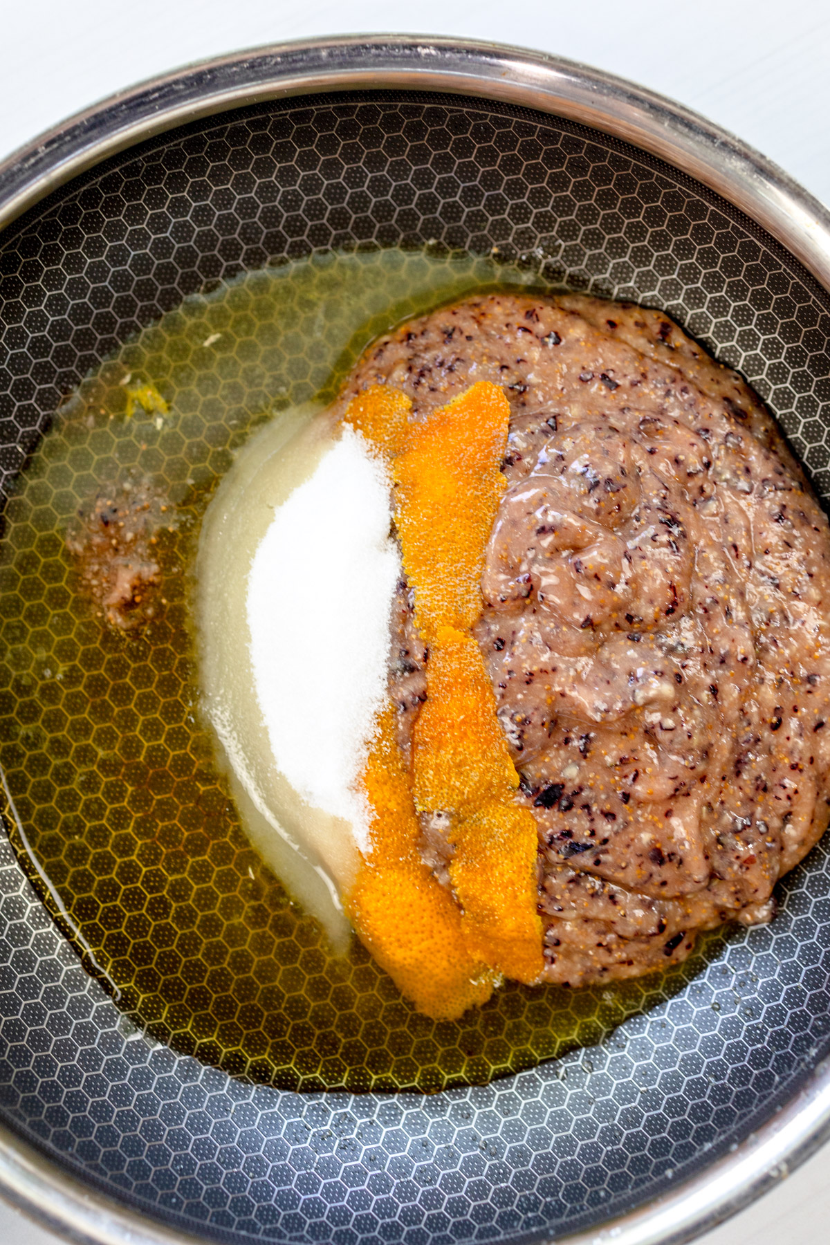 Overhead view of a saucepan with fig jam ingredients combined in it.