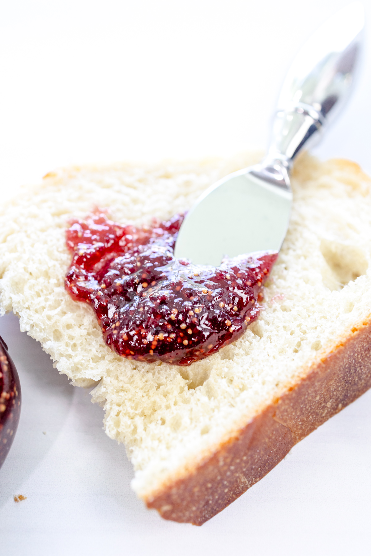 Fig Jam being spread on white bread.