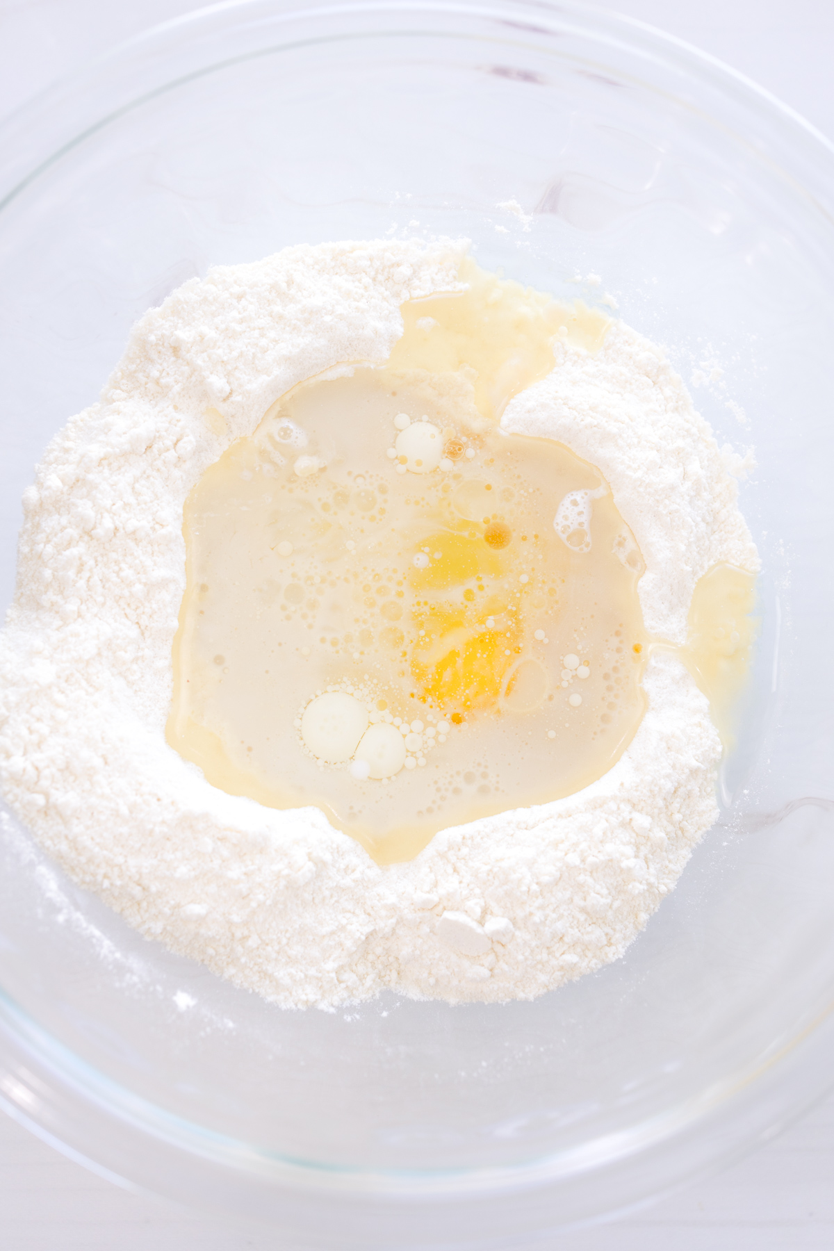 Overhead image of a mixing bowl with wet and dry ingredients ready to be mixed.