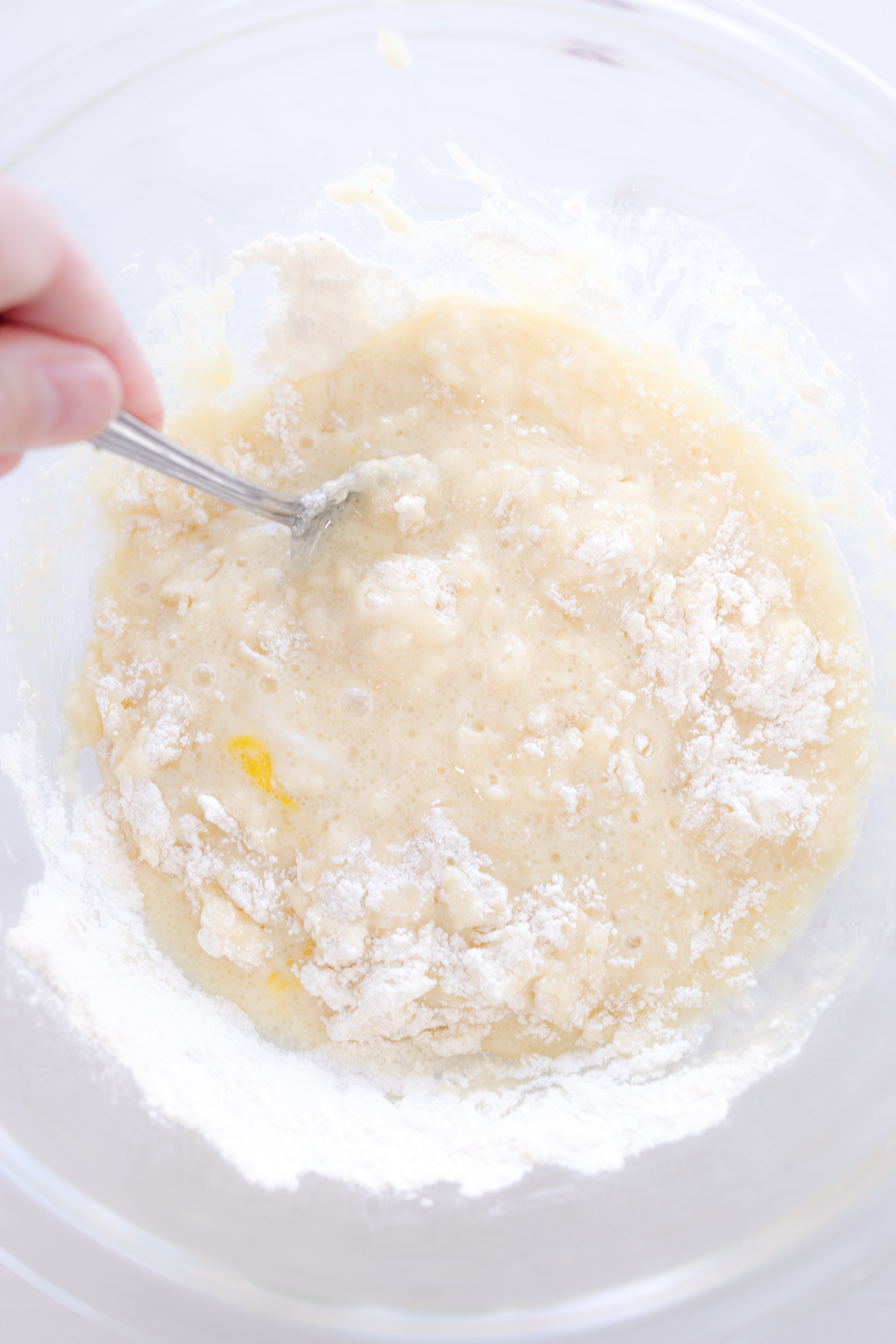 Overhead image of a mixing bowl with wet and dry ingredients being mixed.