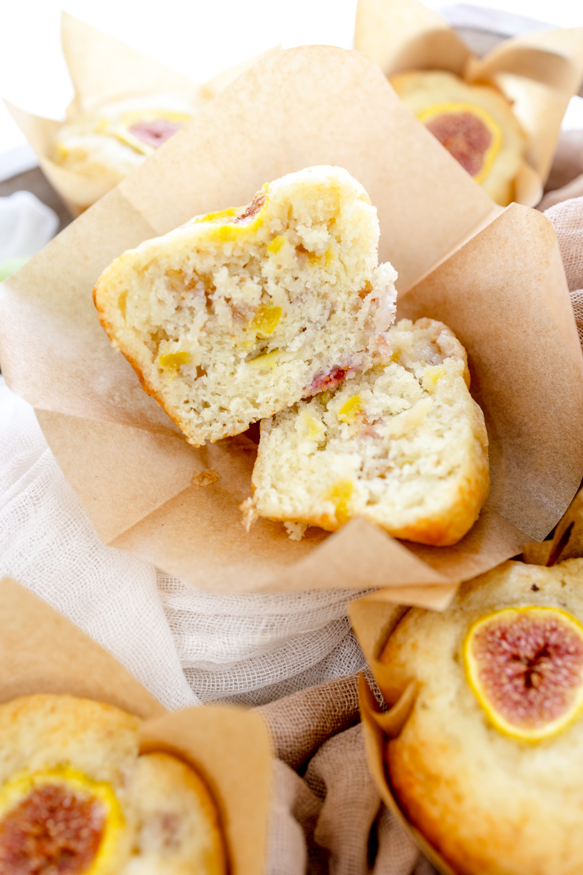 Overhead image of a fig muffin that has been sliced in half with other fig muffins around it.