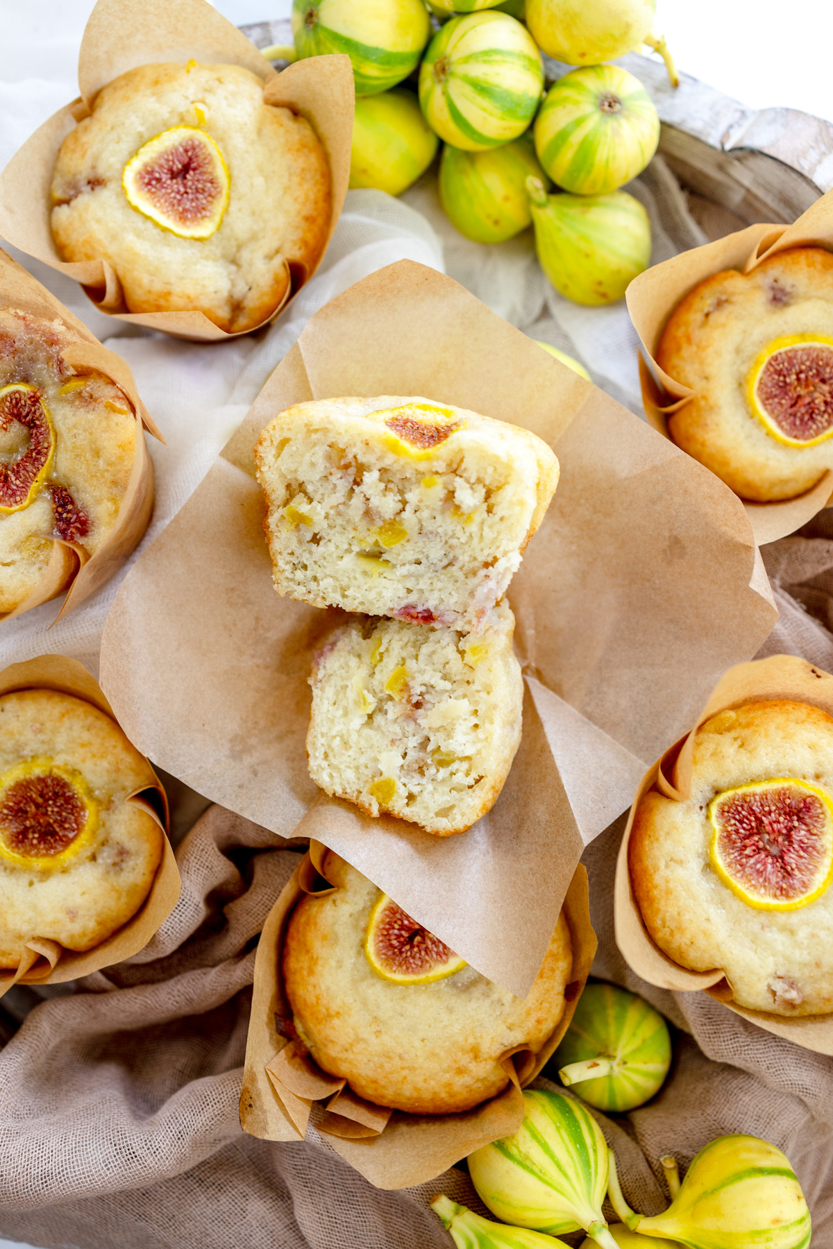Overhead image of a fig muffin that has been sliced in half with other fig muffins around it.
