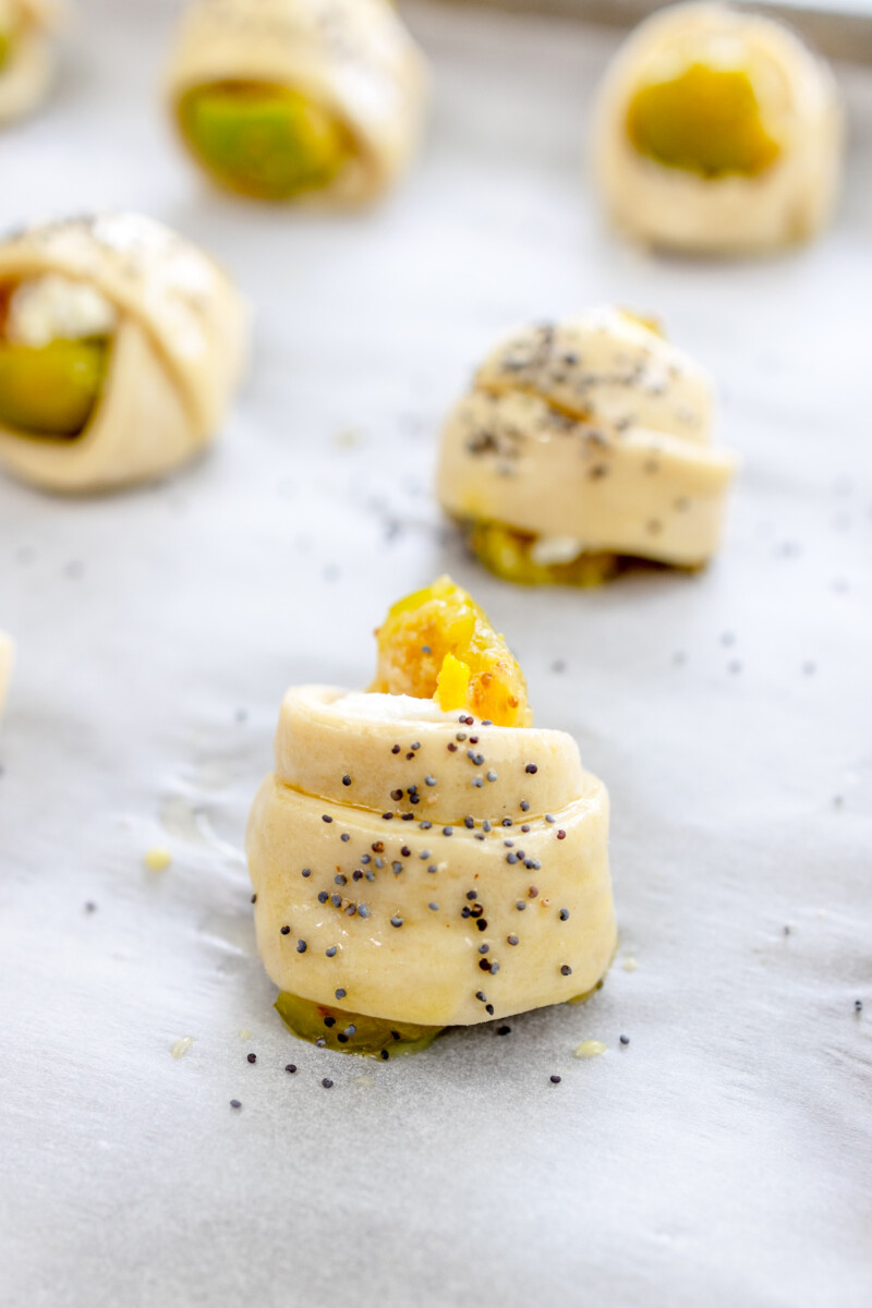Close up image of unbaked Figs in a Blanket sprinkled with seasoning.