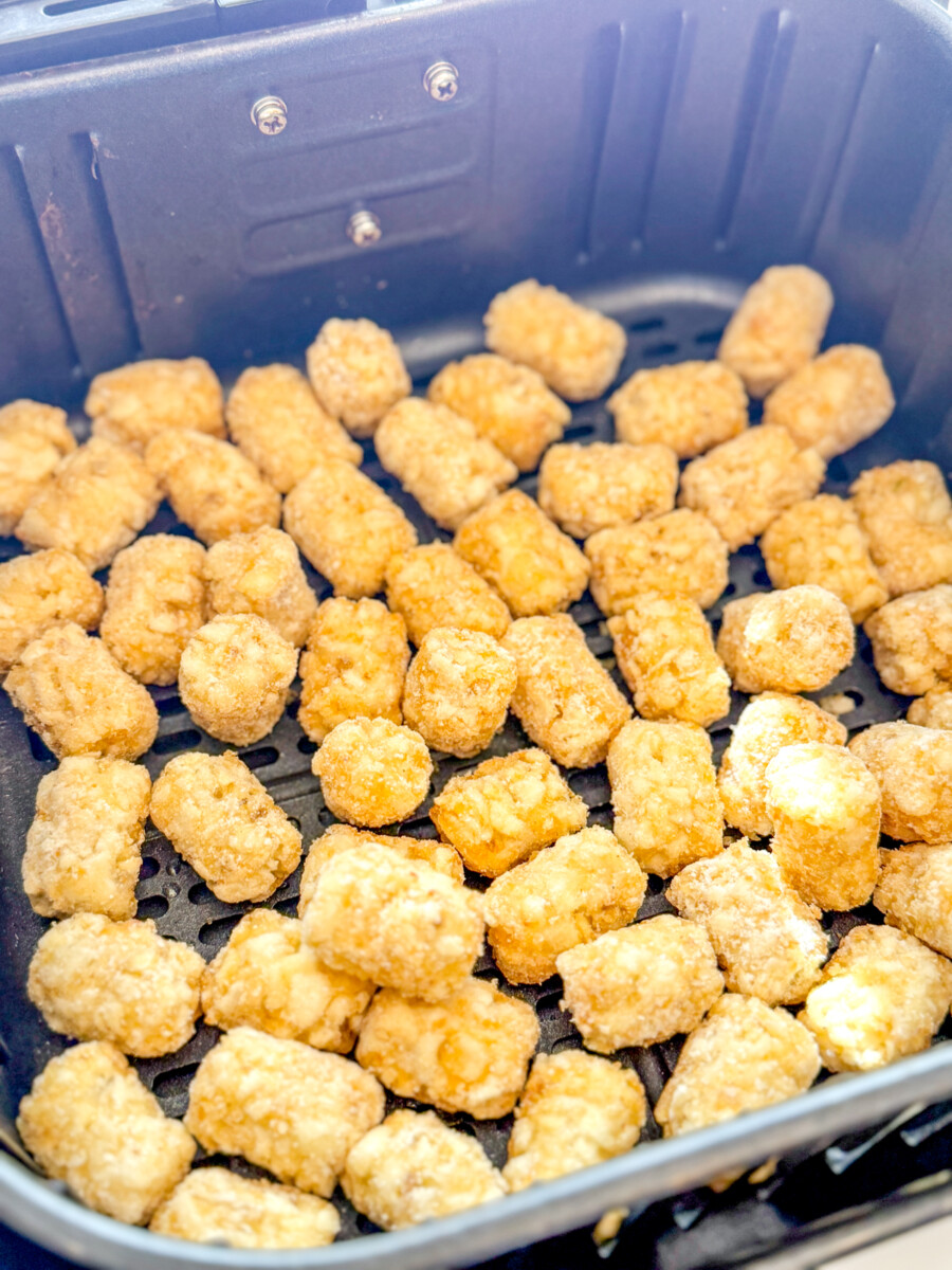 Overhead view of Frozen Tater Tots in an Air Fryer basket.
