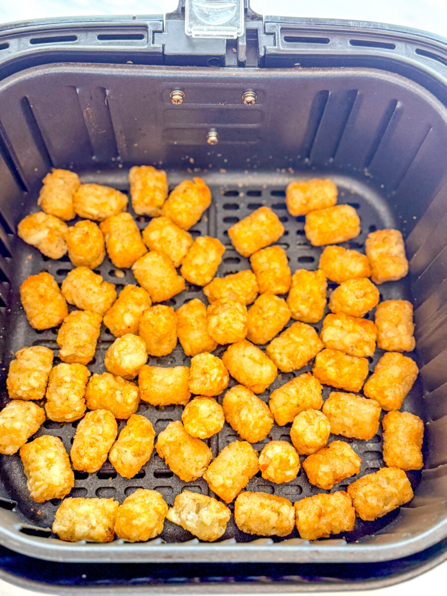 Overhead view of cooked Tater Tots in an Air Fryer basket.