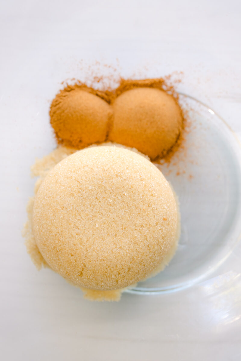 Close up overhead view of brown sugar and cinnamon in a glass bowl.
