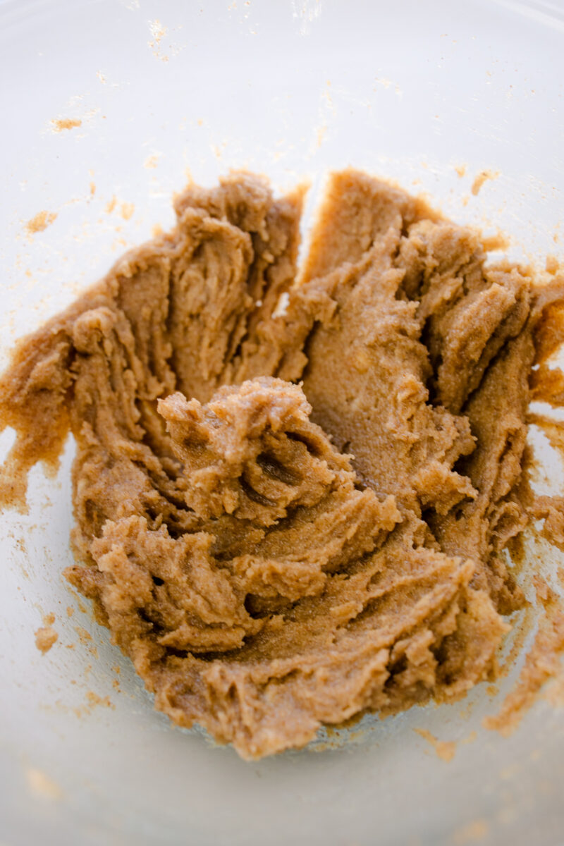 Close up overhead view of cinnamon-sugar-butter mixture in a glass bowl.