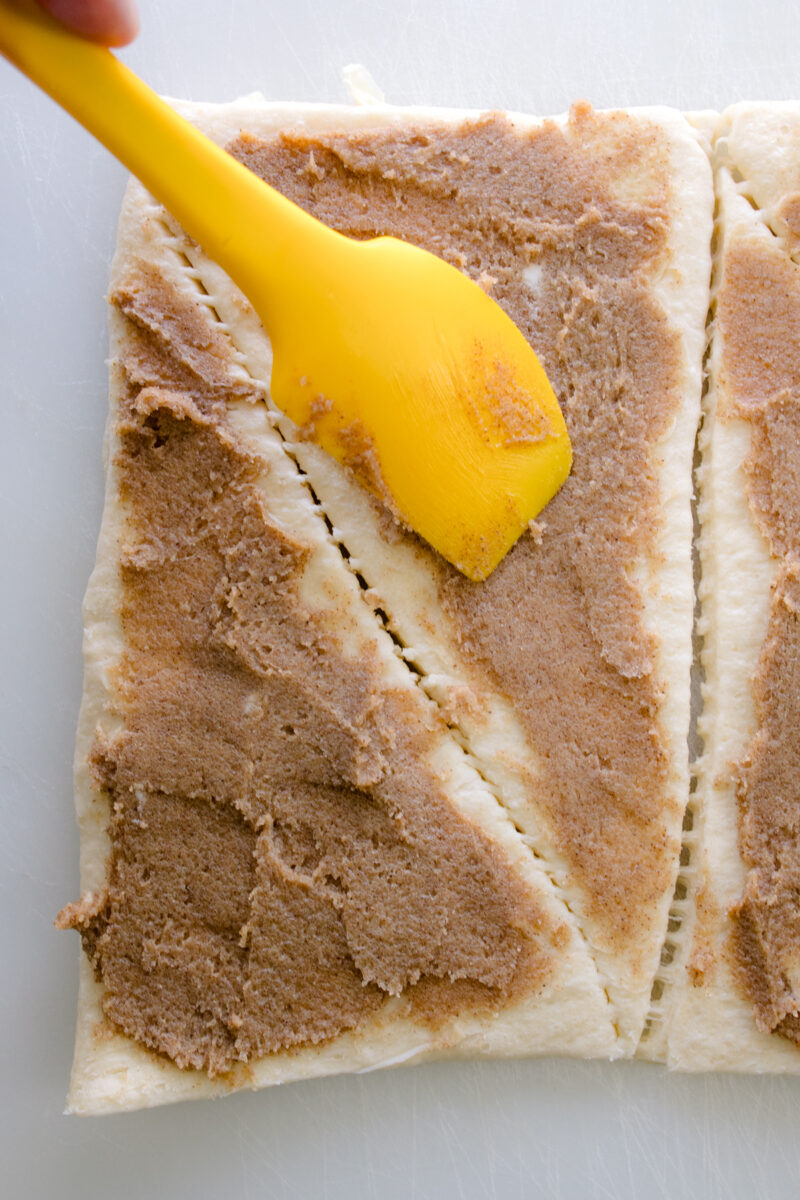 Close up view of crescent roll triangles spread with cinnamon-sugar-butter mixture.