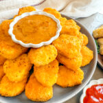 Square image of Air Fryer Frozen Chicken Nuggets on a plate.