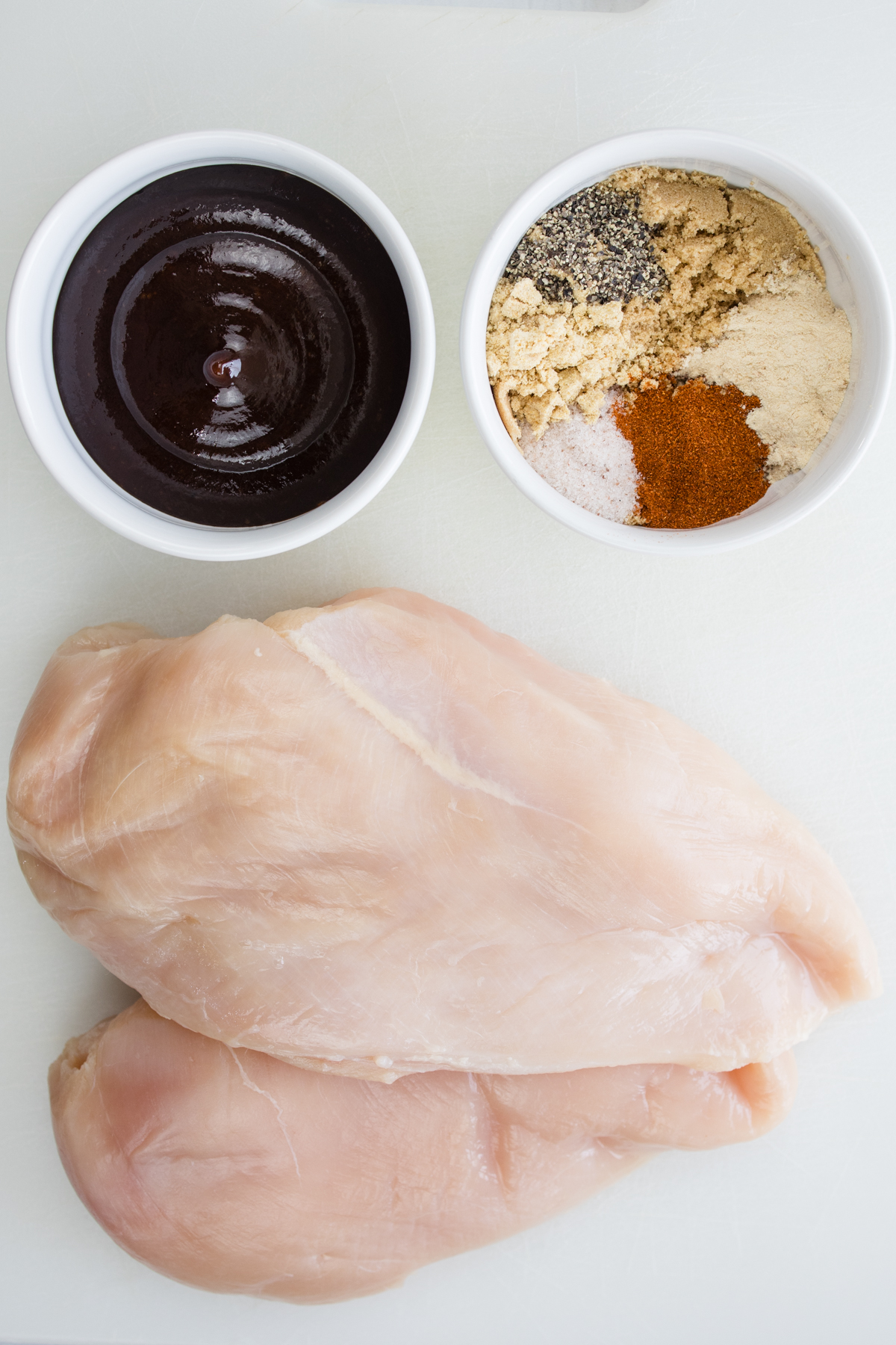 Overhead view of ingredients needed to make Air Fryer BBQ Chicken in small bowls.
