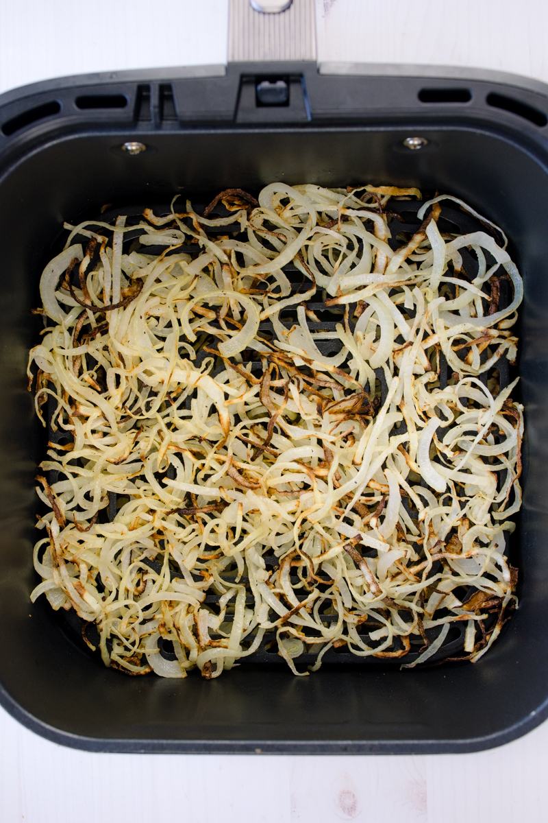 Overhead view of Air Fryer Onions in an air fryer basket.